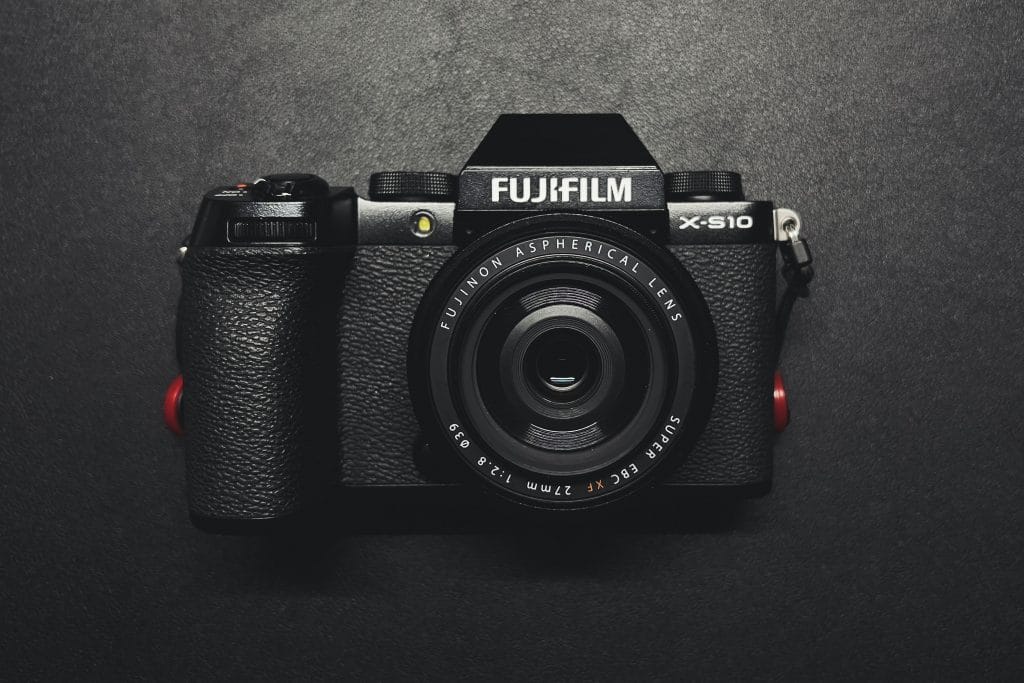 Fujifilm X-S10 - Expert Advice Fujifilm X-S10 mirrorless camera laying lens up on a black surface